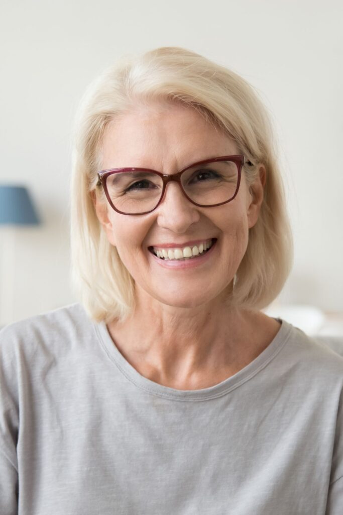 A Woman with glasses smiling.